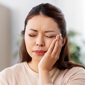 a dental patient holding their jaw
