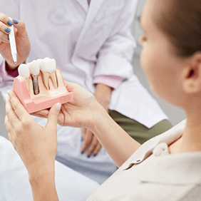 a dentist explaining how dental implants work to a patient