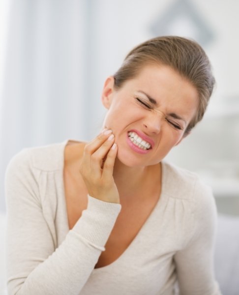 Woman in need of emergency dentistry holding jaw in pain
