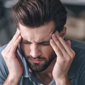 Man with heachache holding his temples