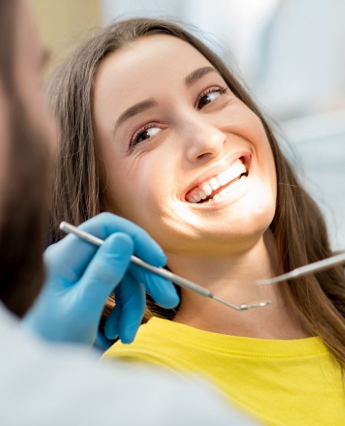 Woman receiving dental checkup to prevent dental emergencies