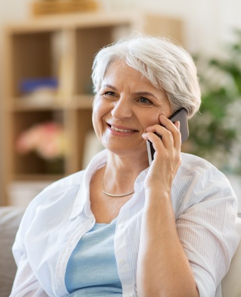 Woman talking on the phone about the cost of dental implants