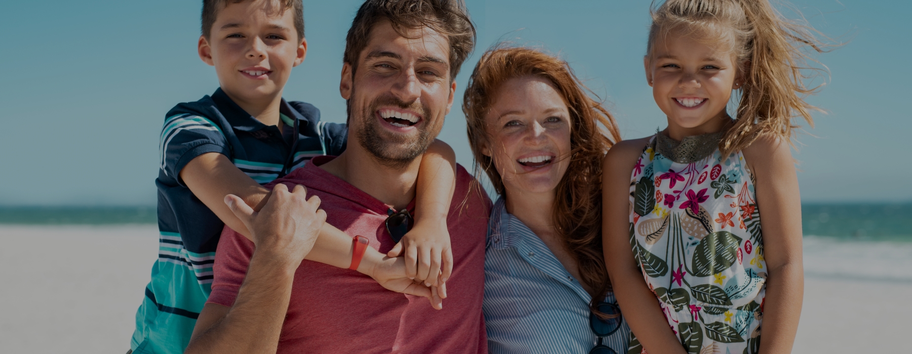 Family of four smiling after visiting their dentist in Glendale, Arizona