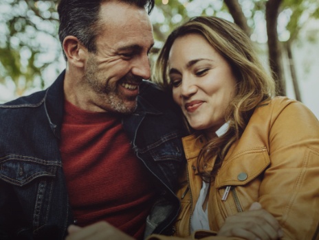 Man and woman smiling together after replacing missing teeth