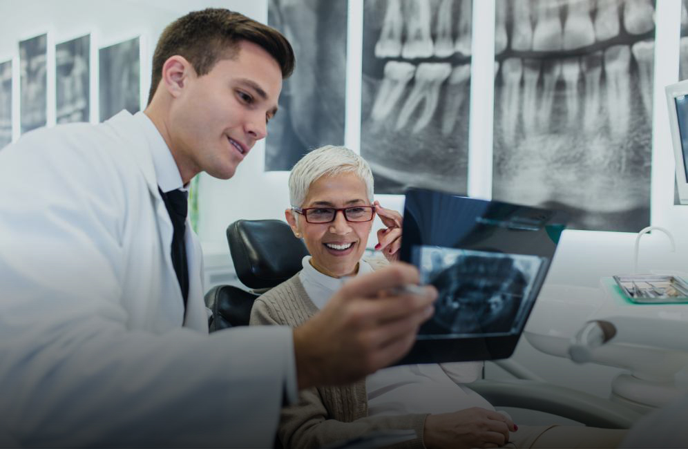 Dentist and dentistry patient looking at digital dental x-rays