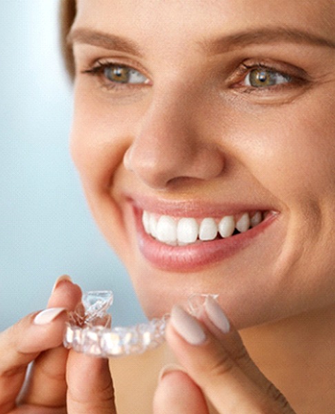 woman holding Invisalign tray in Glendale