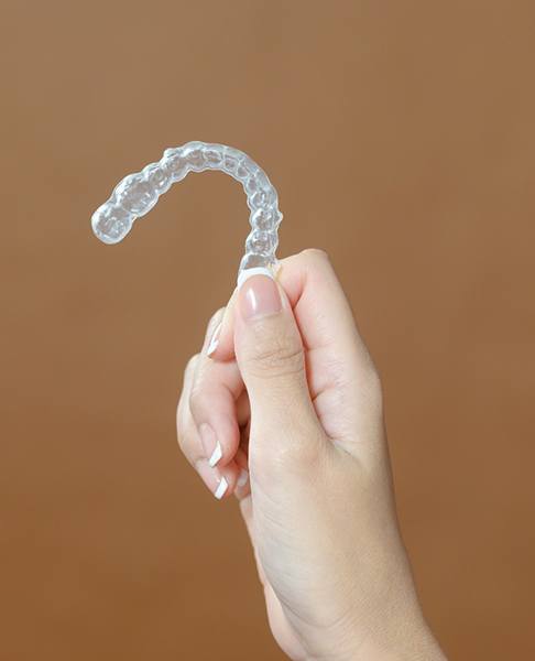 woman’s hand holding Invisalign in Glendale  
