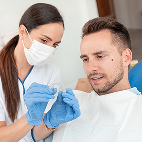 Dentist shows patient Invisalign clear aligner