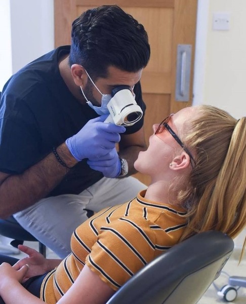 Dentist performing oral cancer screening