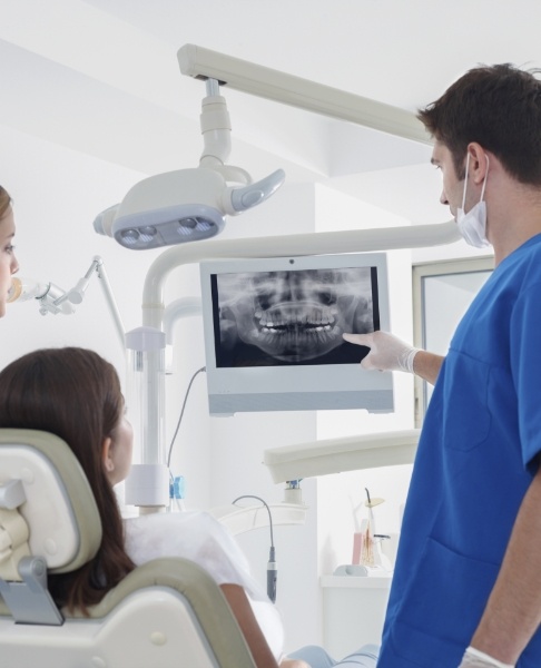 Dentist and patient looking at digital x-rays