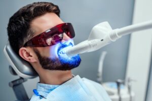Man receiving professional in-house teeth whitening treatment